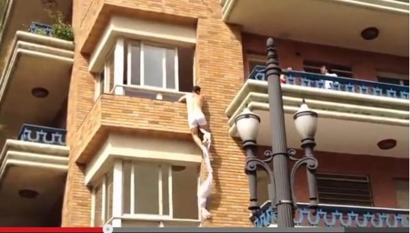 Humour : L'amant saute par la fenêtre de la chambre pendant que le mari s'explique sur le balcon.